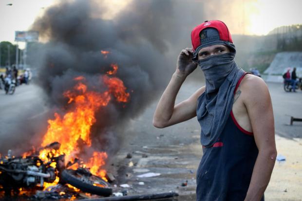 Anti-government demonstrators have taken to the streets in Caracas and have been caught up in violent protests with National Guards.