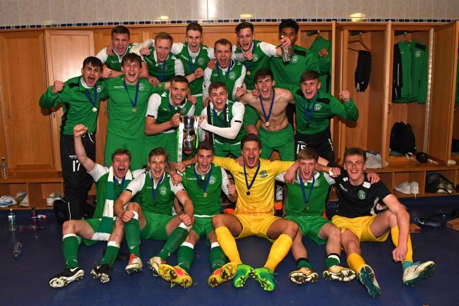 The Hibernian players celebrate with the trophy in the dressing room at full time