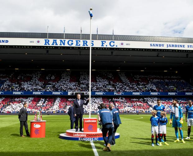 HeraldScotland: Dave King unfurls the Ladbrokes Champions flag with a backdrop of 'Going for 55' at Ibrox